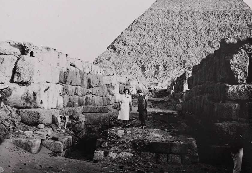 Grete Mostny in weißem Kleid mit Begleiterin vor einem Grab und einer ägyptischen Pyramide
